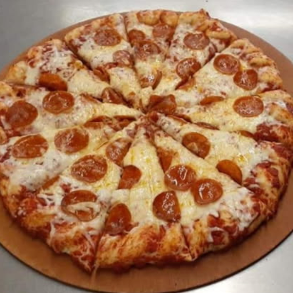 A whole pepperoni pizza, cut into slices, on a wooden pizza peel.